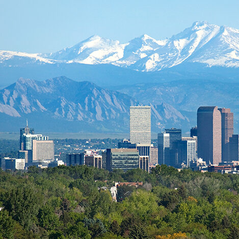 pictured: the Lakewood/Denver, Colorado metro skyline at daytime against the Rocky Mountains